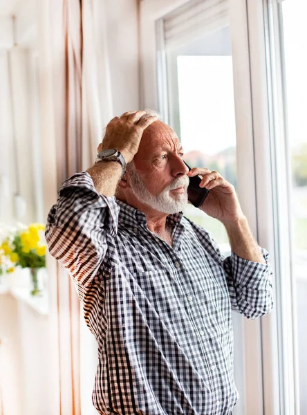 Senior Man Standing Front Window Looking Out Talking Phone Worried — Stock Photo, Image