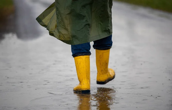 Close Farmer Legs Yellow Gumboots Green Raincoat Walking Puddles Rain — Stock Photo, Image