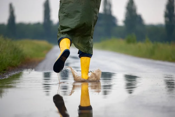 Close Farmer Legs Yellow Gumboots Green Raincoat Running Puddles Rain — Stock Photo, Image