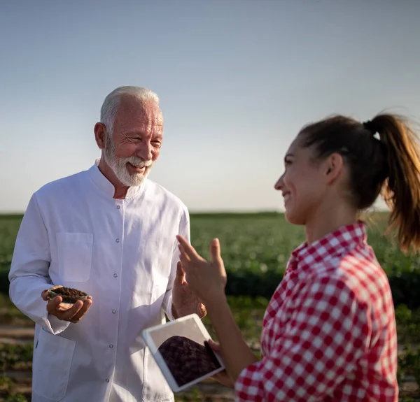 Senior Wetenschapper Agronomist Houdt Bodemmonster Petrischaaltje Praten Glimlachen Jonge Vrouwelijke — Stockfoto