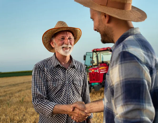 Elderly Farmer Shaking Hands Young Male Farmer Standing Harvested Field — Stok fotoğraf