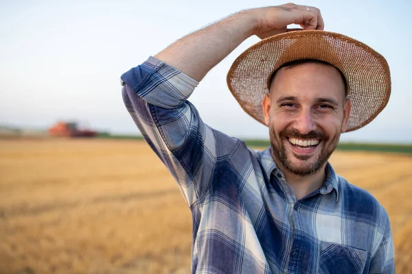 Fazendeiro Bonito Satisfeito Sorrindo Segurando Chapéu Palha Cabeça Campo Durante — Fotografia de Stock