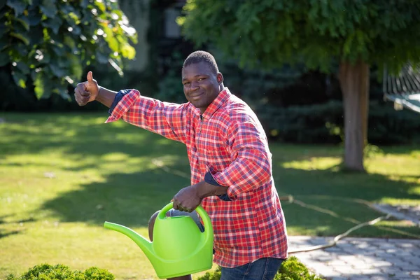 Jonge Afrikaan Amerikaanse Man Water Geven Planten Tuin Tonen Duim — Stockfoto