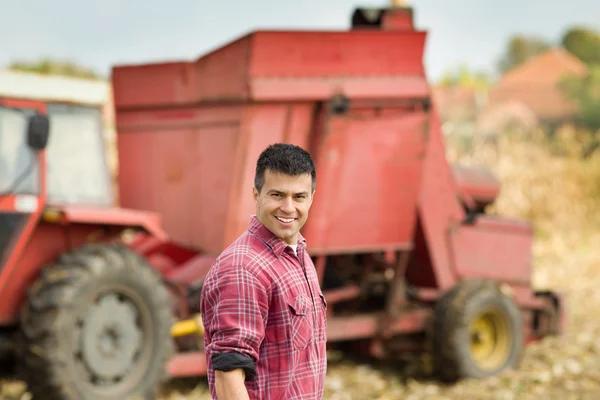 Farmer with agricultural machinery in field — Stock Photo, Image