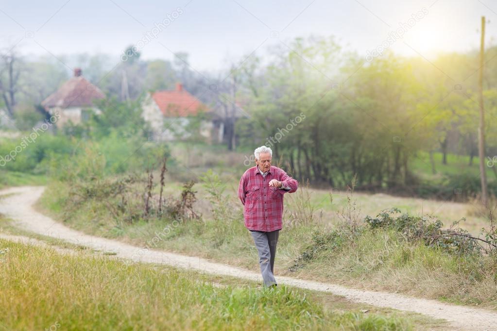 Senior man walkng in village