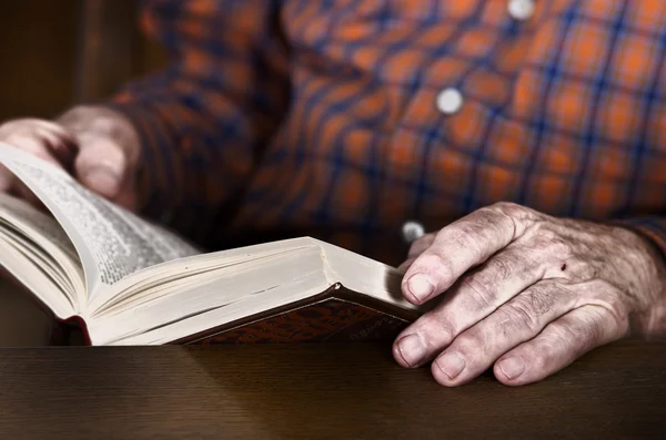 Stary człowiek trzymając się za ręce książkę — Zdjęcie stockowe