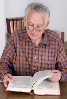Yaşlı adam kitap okuyor.