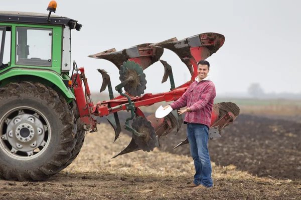 Gelukkig landbouwer naast plough — Stockfoto