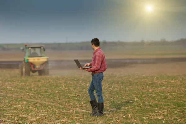 Boer met laptop op landbouwgrond — Stockfoto
