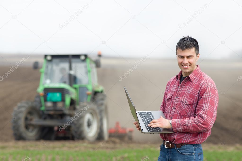 Farmer with laptop on field