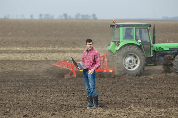 Landwirt mit Laptop und Traktor — Stockfoto