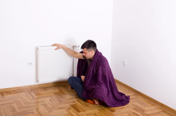 Hombre con manta al lado del radiador — Foto de Stock