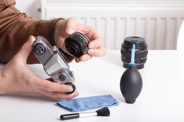 Antigua cámara y lente en mano masculina — Foto de Stock