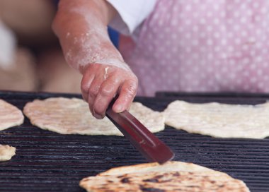 Barbekü üzerinde düz ekmek hazırlama kadın