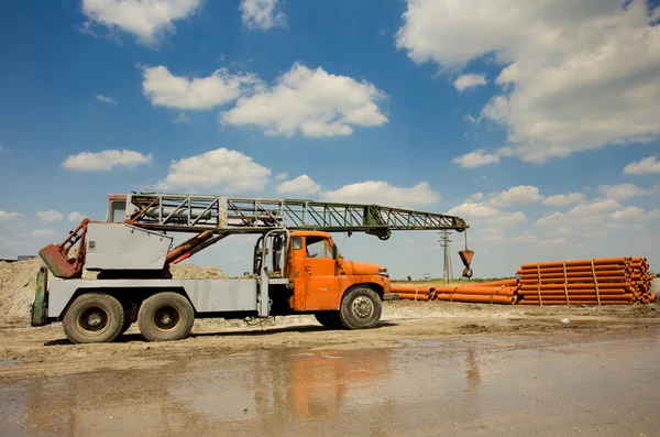 Truck met kraan werken op bouwterrein — Stockfoto