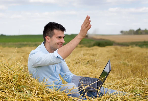 Człowiek z laptopa pozdrawiając — Zdjęcie stockowe
