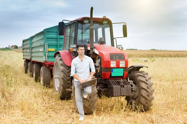 Businessman with laptop and tractor — Stock Photo, Image