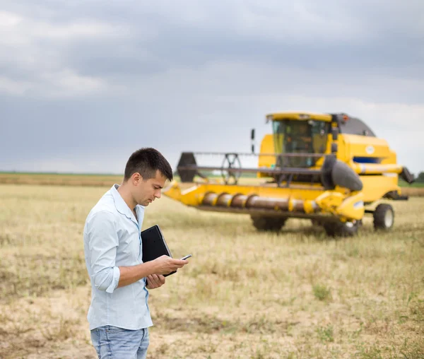 Empresário com laptop e celular phoen em campo — Fotografia de Stock