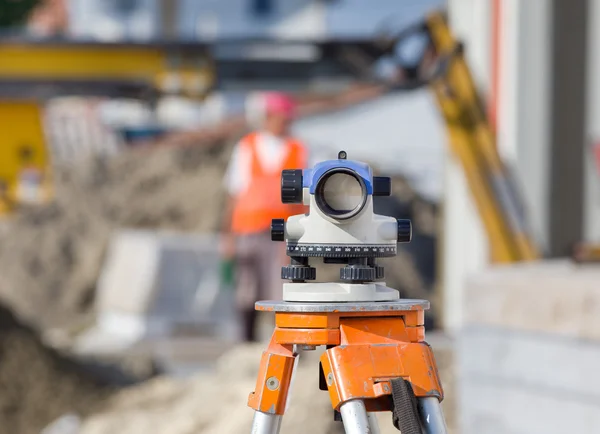 Theodolit und Arbeiter auf der Baustelle — Stockfoto