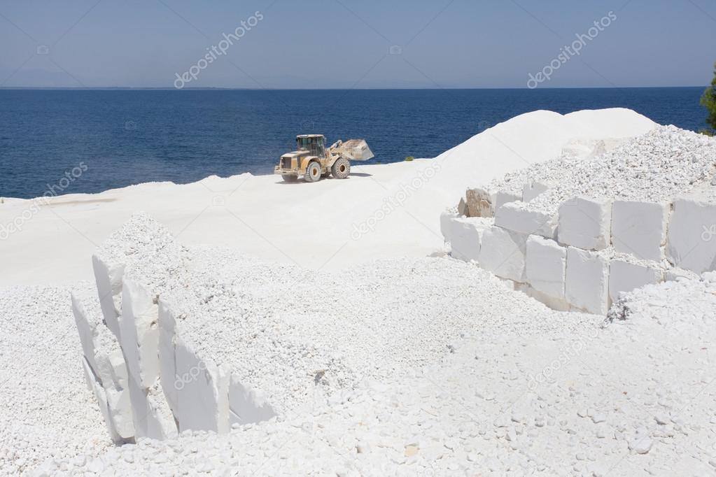 Bulldozer at marble quarry on island