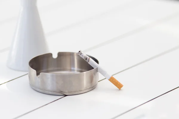 Cigarette in ashtray on the table — Stock Photo, Image