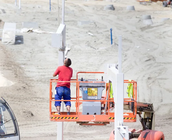 Trabajador instalando pilares metálicos en altura — Foto de Stock