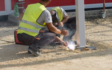 Welders working at construction site clipart