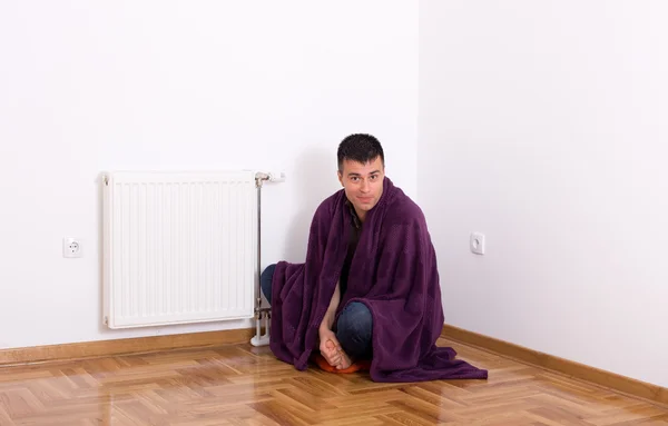 Homem com cobertor ao lado do aquecedor — Fotografia de Stock