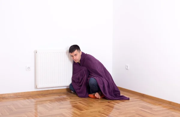 Homem com cobertor ao lado do aquecedor — Fotografia de Stock