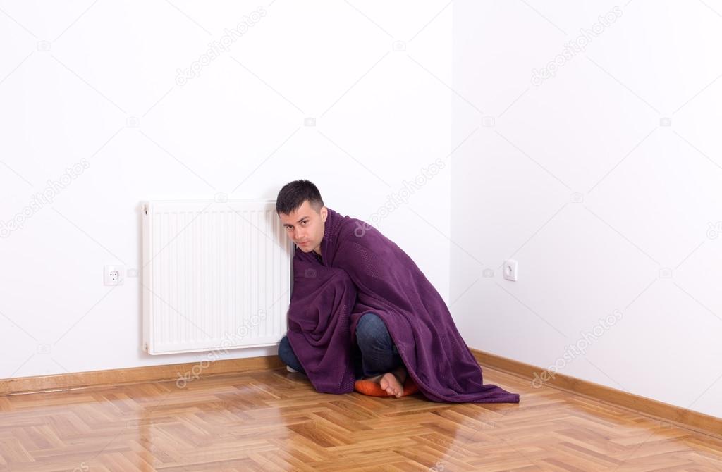 Man with blanket beside heater
