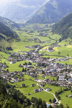 Avusturya 'da güzel bir vadi olan Rauris köyü, yeşil tarlalar ve evler içeren Apls dağlarının arasına kurulmuştur. Güneş ışığı yazın büyüleyici manzarayı güçlendirir..