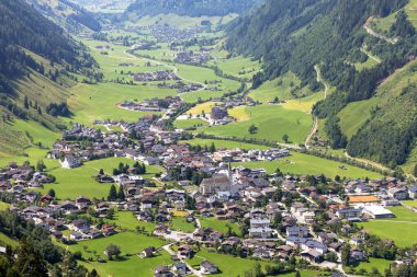Avusturya 'da güzel bir vadi olan Rauris köyü, yeşil tarlalar ve evler içeren Apls dağlarının arasına kurulmuştur. Güneş ışığı yazın büyüleyici manzarayı güçlendirir..