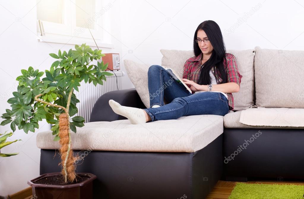 Girl reading book on the sofa