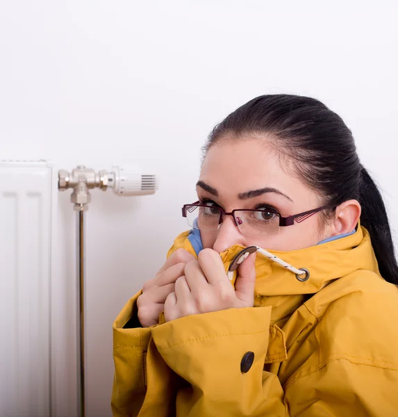 Mujer congelándose junto al radiador — Foto de Stock