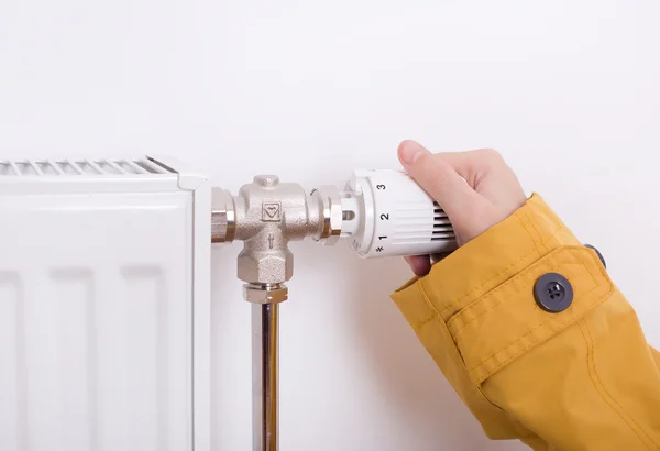 Female hand adjusting heater — Stock Photo, Image