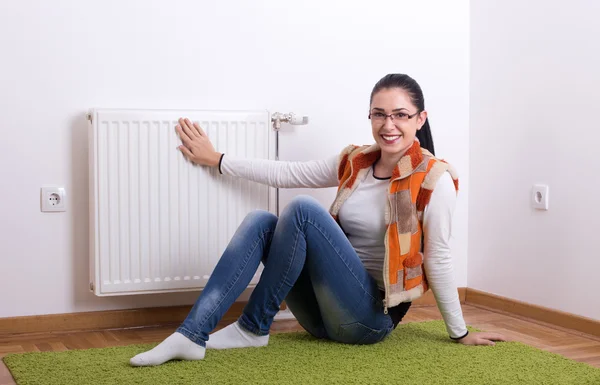 Žena vedle teplý radiátor — Stock fotografie