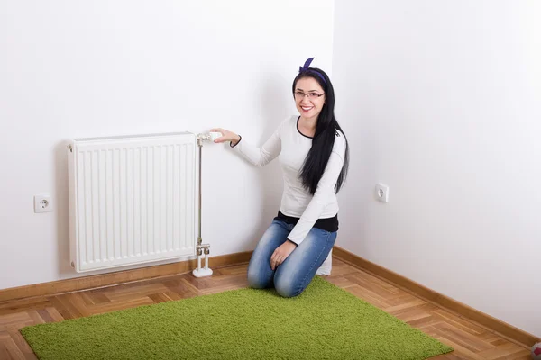 Woman adjusting heating — Stock Photo, Image