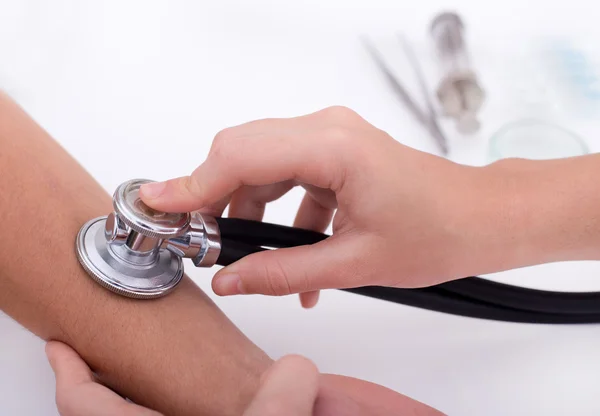 Doctor measuring pulse with stethoscope — Stock Photo, Image