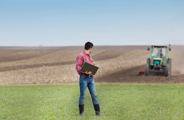 Farmář s notebookem v poli — Stock fotografie