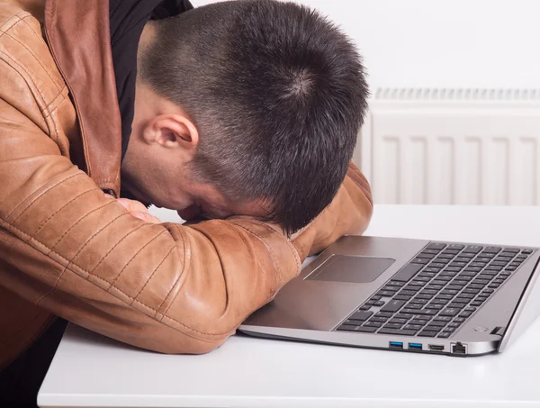 Man sover över laptop — Stockfoto