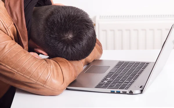 Mann schläft über Laptop — Stockfoto