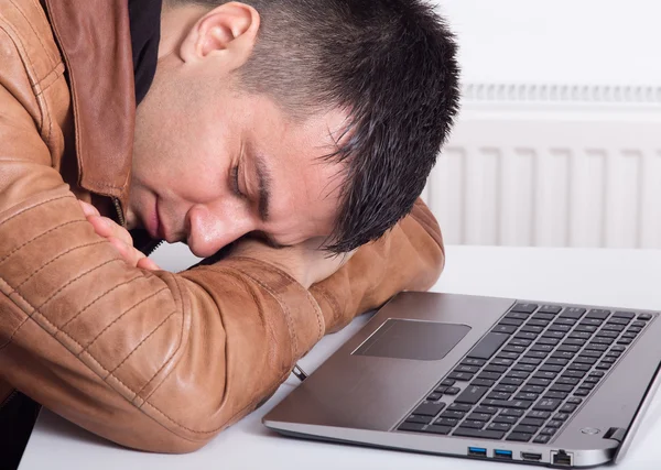 Man sover över laptop — Stockfoto