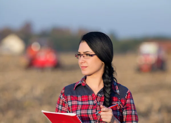 Kvinna med traktor på fältet — Stockfoto