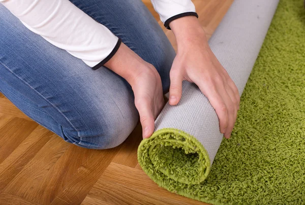 Woman rolling carpet — Stock Photo, Image