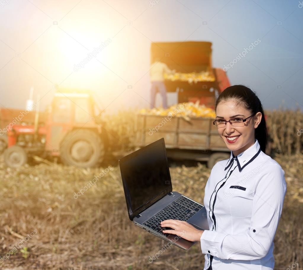 Woman agronomist with laptop in corn field