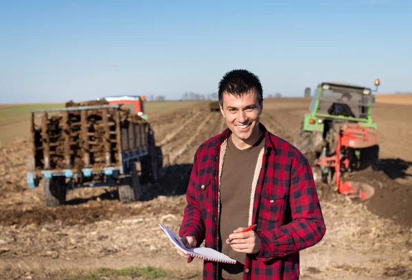 Agricultor con tractores en el campo —  Fotos de Stock