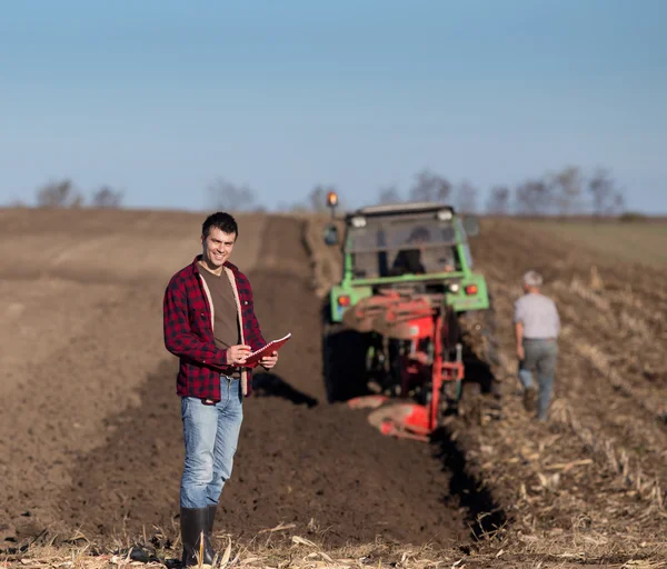 Farmář s traktorem na pole — Stock fotografie