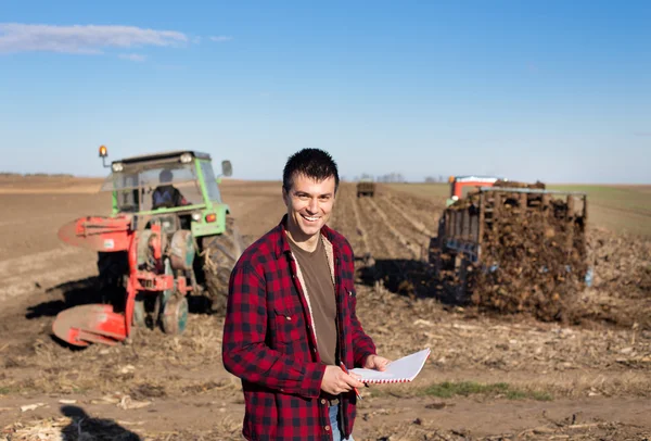 Agricultor com tratores em campo — Fotografia de Stock