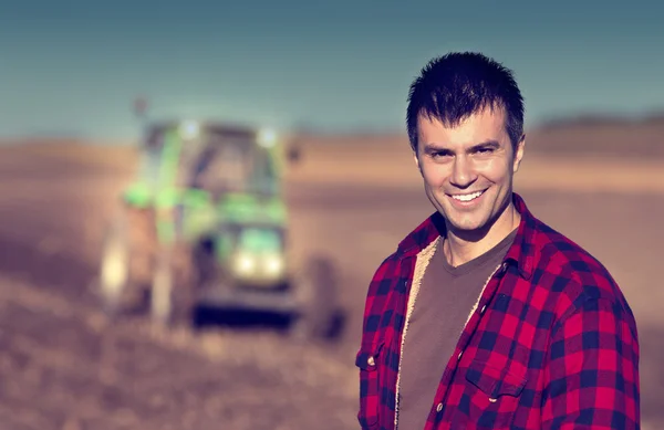 Farmer with tractor on field — Stok fotoğraf