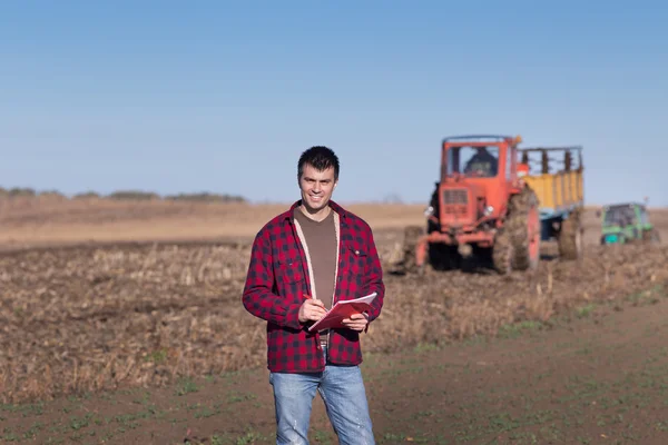 Agricultor com tratores em campo — Fotografia de Stock